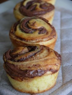 three cinnamon rolls sitting on top of a paper towel