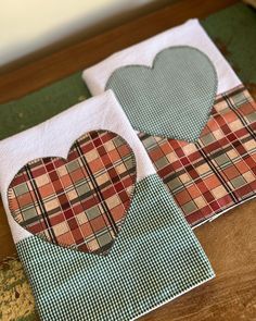 two pieces of paper with hearts on them sitting on a table next to each other