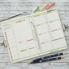 an open planner with pens and markers on it