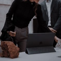 two people looking at a laptop on a table