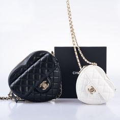 The Chanel CC In Love bags are the ultimate statement piece for any fashion-forward individual. Their heart-shaped design and classic Chanel details make them a must-have for any handbag lover. The white lambskin leather version, known as the "Clutch with Chain," is a perfect example of the brand's iconic style. The quilted leather, interwoven leather and chain strap, and CC turnlock closure all come together to create a truly luxurious piece. And with its mini size of just 4.7 inches across and 5.1 inches tall, it's the perfect size for carrying all your essentials. The pale gold hardware adds an extra touch of sophistication, making these bags the perfect choice for any stylish fashionista. Chanel Details, Cute Mini Bags, Jimmy Choo Clutch, Heart Shaped Bag, Chanel Clutch, Bag Illustration, Classic Chanel, Designer Clutch Bags, Womens Designer Handbags