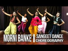 four young women are dancing on the dance floor with their arms in the air and one woman is holding her hands up