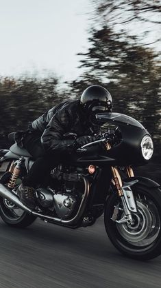 a man riding on the back of a black motorcycle