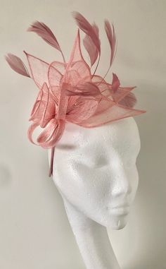 A gorgeous light pink/ blush coloured Fascinator crafted out of light Sinamay fabric. A striking full flower and leaf design, complemented by delicate feather detailing in the same shade makes this Fascinator hat a beautiful addition to any outfit. This piece sits firmly on the head with a co-ordinating satin coloured headband. This design can also be created on a comb please write this in the notes at checkout if you would prefer it on a comb. Headband measures 0.5cm wide. *All fascinators are light weight and comfortable to wear. *Handmade with love, packed and shipped in a sturdy box to ensure a safe delivery. *Looking for a customised fascinator or headpiece piece? Please feel free to send me a message! *If you'd like to send a phot of your outfit I can assist with colour matching/ adv Elegant Pink Hair Accessories For Royal Ascot, Pink Headband Fascinator For Races, Pink Pinched Crown Headpiece For Races, Pink Headband Fascinator For Evening, Pink Evening Fascinator Headband, Elegant Pink Headband Fascinator, Pink Headpieces For Royal Ascot Event, Elegant Pink Headband For Kentucky Derby, Elegant Pink Fascinator For Event