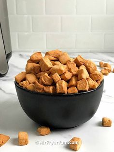 a black bowl filled with dog food on top of a counter