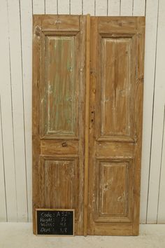 two wooden doors with chalkboard on the bottom and bottom, in front of a white wall