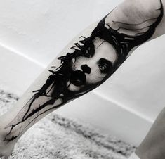 a man's leg with a black and white portrait tattoo on the left arm