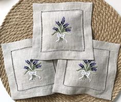 three napkins with purple flowers on them