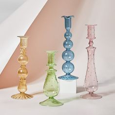 four different colored glass vases sitting next to each other