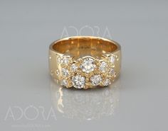 a yellow gold ring with three diamonds on the side and two rows of small round stones