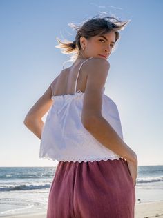 The Rita top updated in a crisp white eyelet fabric rescued from a dead stock warehouse. Pretty scallop edging and delicate embroidery give this classic white tank a vintage feel. Adjustable ties and roomy elastic fit accommodates a multitude of sizes. 100% cotton deadstock One Size Top elastic relaxed flat 11", stretches to 20" Bottom opening flat 22.5" Body length from shoulder is 19" Falls at waist for a slightly cropped fit Fully lined Hand wash cold, line dry Consciously made in small batch Sleeveless Cotton Eyelet Top, Summer Tops With Scalloped Edges For Daywear, Summer Cotton Tops With Scalloped Edges, Summer Top With Scalloped Edges For Day Out, Sleeveless Scalloped Edges Tank Top For Summer, Summer Sleeveless Tank Top With Scalloped Edges, White Sleeveless Eyelet Top, White Sleeveless Top With Eyelet Details, White Scalloped Edges Tops For Summer