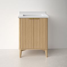 a white sink sitting on top of a wooden cabinet next to a wall in a room