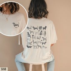 a woman sitting on a stool wearing a t - shirt with dogs printed on it