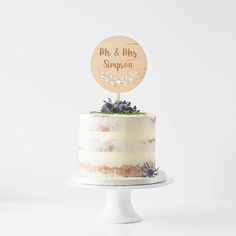 a white cake with a wooden sign on top that says mr and mrs harper to the right