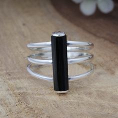 Raw Black Tourmaline Ring, Rough Stone Ring, Birthstone Jewelry, Women Rings, Crystal Ring, 925 Silver Rings, Gift For Her, Tourmaline Stick 𝐒𝐩𝐞𝐜𝐢𝐟𝐢𝐜𝐚𝐭𝐢𝐨𝐧𝐬: 𝐌𝐚𝐭𝐞𝐫𝐢𝐚𝐥: 925 Sterling Silver 𝐆𝐞𝐦𝐬𝐭𝐨𝐧𝐞: Black Tourmaline ❖ Gemstone Shape: Rough ❖ Gemstone Size: 4x16 MM ❖ Gemstone Number: 1 ❖ Total Weight: 3.5 Gram ❖ Gemstone Setting: Bar Setting ❖ SKU: 1236-AJ-12325 Black Tourmaline, also known as Schorl, is a highly revered crystal with incredible metaphysical properties. It derives its name from the Dutch word "turamali," meaning "stone with mixed colors." However, despite its name, Black Tourmaline is typically found in shades of deep black or dark brown. The healing properties of Black Tourmaline include promoting a sense of power and self-confidence, which can b Rough Stone Ring, Rings Crystal, Raw Black Tourmaline, Black Tourmaline Ring, Bar Ring, Ring Birthstone, Silver Bar, Tourmaline Ring, Crystal Ring