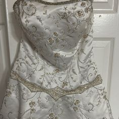 a white dress with gold beading on it