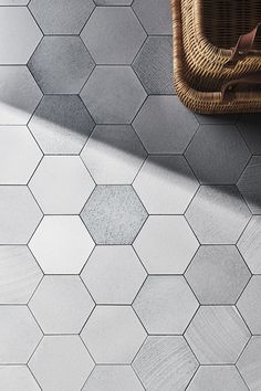 a basket sitting on top of a white tiled floor