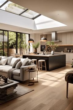 a living room filled with furniture next to a kitchen and an open floor plan area