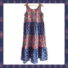 Navy Floral - Hand Block printed women's sleeveless sundress.  Extra soft cotton and extremely comfortable fit and texture.  Perfect for; vacation, a day at the beach, picnic, farmers market, to run errands, a weekend brunch, or dress it up with a cardigan or dress topper for a stylish dress for any occasion. Description: Three-tiered women's dress with swing shape and side seam pockets. Flattering for most body types. Lightweight breathable 100% cotton. *  Care Instructions: Hand wash *  Fabric: 100% cotton *  Season: Spring/Summer *  Weight: 10.56 oz (299.37 g) *  Dimensions: 27 in (68.6 cm) Eco-friendly information *  Packaging: Recyclable *  Product Materials: Plastic-free *  Production: Fair trade Sleeveless Cotton Sundress For Beach Season, Cotton Sleeveless Dress For Beach Vacation, Bohemian Cotton Sleeveless Sundress, Bohemian Sleeveless Cotton Sundress, Cotton Sleeveless Maxi Dress For Beach Season, Sleeveless Cotton Maxi Dress For Beach Season, Bohemian Printed Maxi Length Sleeveless Dress, Bohemian Printed Maxi Sleeveless Dress, Multicolor Cotton Sundress For Beach Season