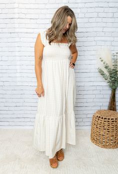 Get your boho-chic on with our Mel Dress! This playful maxi features a smocked top for a perfect fit, while the plaid print and ruffled hem add a touch of whimsy. Perfect for any occasion, this dress will have you feeling stylish and comfortable. 100% Polyester Day Out Maxi Dress With Smocked Bodice, Cotton Maxi Dress With Smocked Bodice For Day Out, Chic Maxi Dress For Picnic, Summer Smocked Maxi Dress With Ruffles, Beige Maxi Dress With Smocked Back For Day Out, Chic Maxi Sundress For Picnic, Ruffled Maxi Length Picnic Dress, Ruffled Sundress Maxi For Picnic, Casual Gingham Tiered Dress