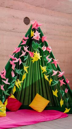 a paper tree with pink and yellow origami birds hanging from it's sides