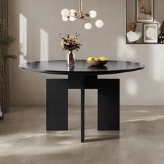 a dining table with a bowl of fruit on it in front of a white wall