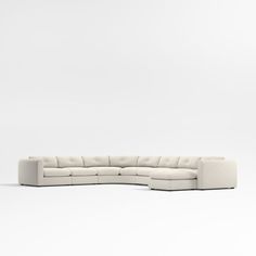 a white sectional couch sitting on top of a white floor