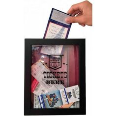 a hand holding a ticket in a black frame