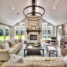 a living room filled with furniture and a fire place under a chandelier over a fireplace