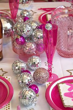 the table is set with pink and silver decorations