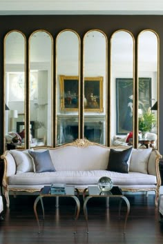 a living room filled with furniture and mirrors