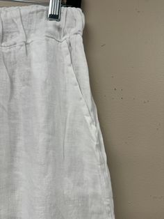 Indulge in luxury with these Button Detail Linen Pants. Made from premium Italian linen, these pants feature sophisticated button detailing, a flattering wide leg, and an elastic waist with drawstring for the perfect fit. With two front pockets and a distressed hem, these pants offer both style and comfort, making them a must-have for any elegant and cabin chic wardrobe. One Size (fits S-L) Casual Linen Pants With Button Closure, Summer Linen Pants With Button Closure, Linen Trousers With Button Closure, High Waist Linen Bottoms With Button Closure, High Waist Linen Bottoms With Buttons, Relaxed Fit Linen Pants With Buttons, White Linen Wide Leg Pants With Straight Hem, Wide Leg Linen Pants With Buttons, Elegant Linen Bottoms With Buttons