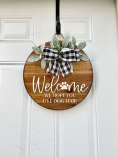 a welcome sign hanging on the front door to someone's dog house in their neighborhood