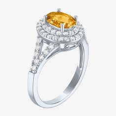 a yellow diamond ring with diamonds around the band and an oval center stone on top