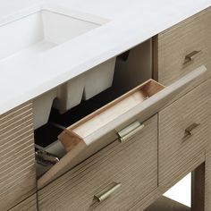 an open drawer in a bathroom sink next to a counter