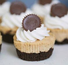 several cupcakes with white frosting and chocolate decorations