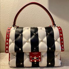 This Is An Authentic Valentino Garavani Nappa Striped Medium Candystud Top Handle Bag White Black & Red At An Unbeatable Price! This Chic Crossbody Bag Is Beautifully Crafted Of Striped Lambskin Leather In Black And White. It Is Accented With Polished Light Gold Pyramid Studs Throughout, A Rear Patch Pocket, A Looping Leather Top Handle, And An Optional Studded Leather Shoulder Strap. The Crossover Flap Opens With A Matching Gold Turn-Lock To A Black Fabric Interior With Zipper And Patch Pockets Valentino Purse, Valentino Designer, Chic Crossbody Bag, Black Lipstick, Lipstick Case, Valentino Black, Gold Bag, Designer Handbag, Studded Leather