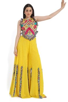 Yellow and multi color sleeveless back tie-up choli with all over bohemian tribe vibe embroidery and tassel embellishments. Paired with a mukaish dot embroidered sharara with tassel detailing. - Aza Fashions Fitted Multicolor Embellished Sharara, Fitted Embellished Multicolor Sharara, Yellow Bohemian Designer Dress, Bohemian Multicolor Sets With Gota Work, Multicolor Embroidered Sleeveless Sets, Multicolor Sleeveless Embroidered Sets, Yellow Bohemian Festive Sets, Bohemian Festive Yellow Set, Bohemian Sleeveless Sharara For Diwali