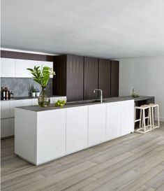 a modern kitchen with white cabinets and wood flooring