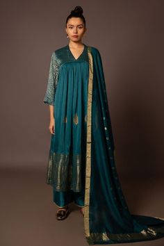 Teal tik chanderi kurta with banarasi gold borders and leaf pitta hand embroidered hemline. Comes with pant and a dupatta.
Components: 3
Pattern: Hand embroidered
Type Of Work: Leaf pitta
Neckline: V Neck
Sleeve Type: Three quarter
Fabric: Tik chanderi, Banarasi
Color: Blue,Green
Other Details: 
Model Height: 5ft 11inches, wearing size S
Occasion: Mehendi and Haldi - Aza Fashions Festive Kurta With Dupatta For Rituals, Chanderi Traditional Drape Kurta For Rituals, Traditional Chanderi Kurta For Rituals, Chanderi Kurta With Dupatta For Rituals, Straight Kurta With Zari Work For Rituals, Traditional Drape Chanderi Kurta For Rituals, Anarkali Kurta For Eid Rituals, Chanderi Kurta With Zari Work For Rituals, Anarkali Kurta With Zari Work For Rituals