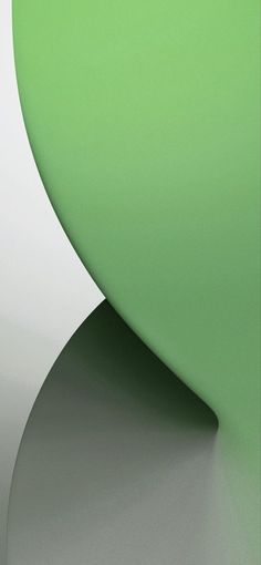 an abstract green and white wallpaper with curved lines on the bottom right hand corner