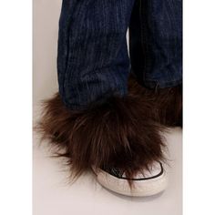 a person's feet with furry shoes on top of their ankles and jeans in front of them