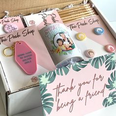 an open box with some items in it and a thank you for being a friend keychain