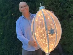 a man standing next to a large light ball with lights on it's sides