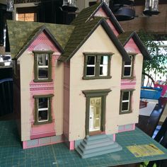 a pink doll house sitting on top of a table