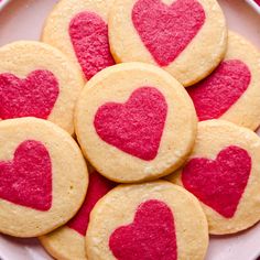 heart shaped cookies are arranged on a plate