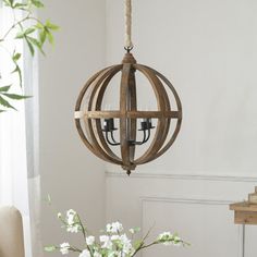 a wooden chandelier hanging from a ceiling in a room with white flowers on the table