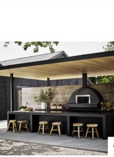 an outdoor kitchen with bar stools and tables in front of the grill, next to a