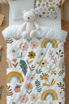 a white teddy bear sitting on top of a bed next to pillows and pillow cases