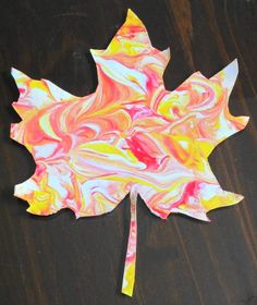 a leaf made out of colored paper on a table